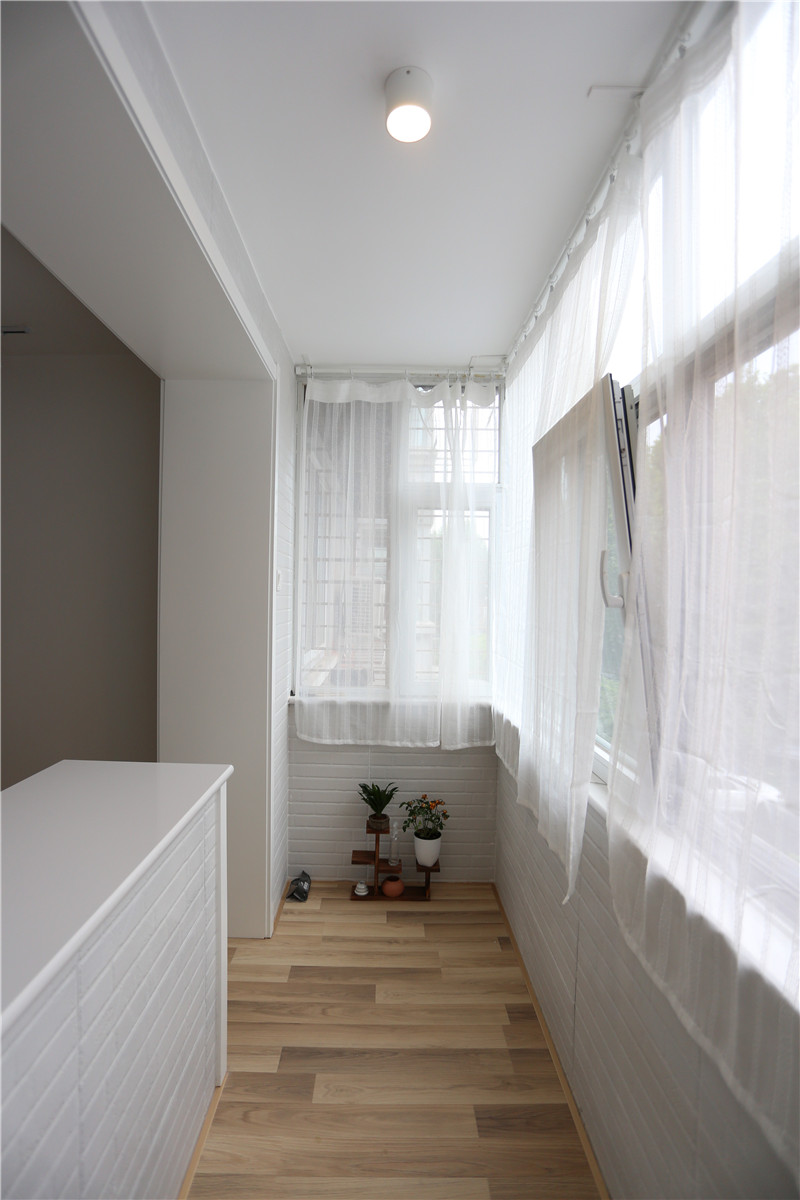 客厅和阳台之间的隔断打掉了,只留下配重墙,虽然拍摄时阴雨天,可室内