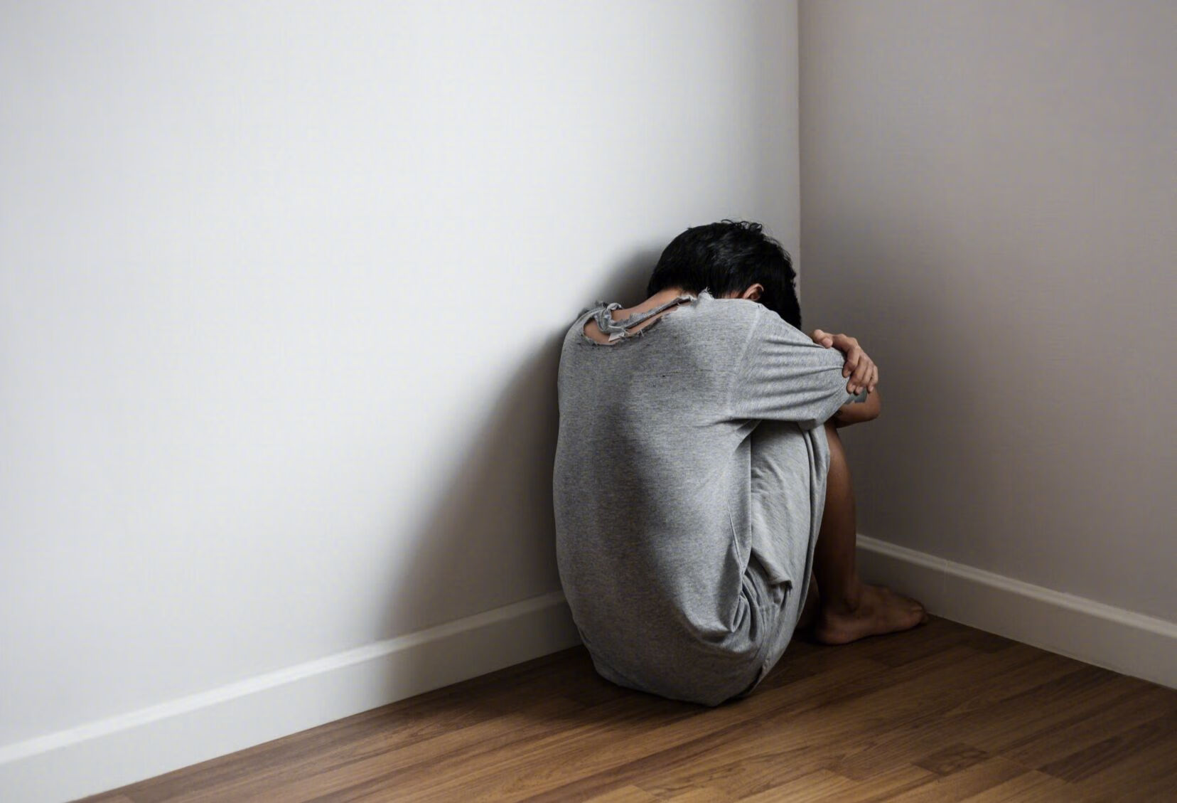 捂着头萎靡不振背影脆弱的少年年轻男孩蜷缩在角落背影蹲在角落emo